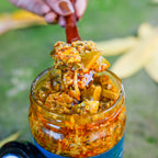 Spoon lifting chunky Kulcha Pickle from an open Mahalaxmi Farm jar.
